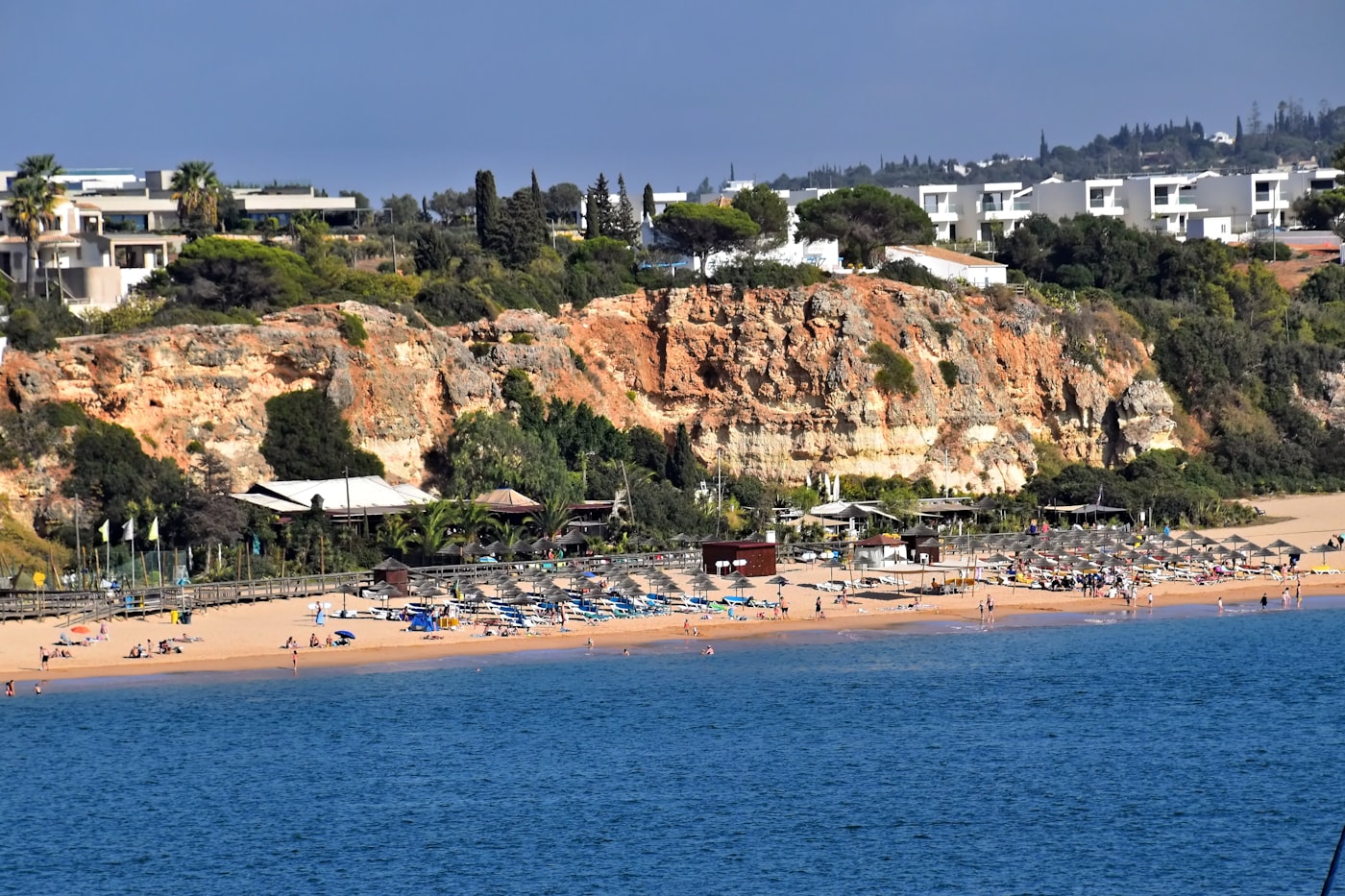 Strand met okerkleurige kliffen en parasols aan de Algarve-kust bij Praia da Rocha