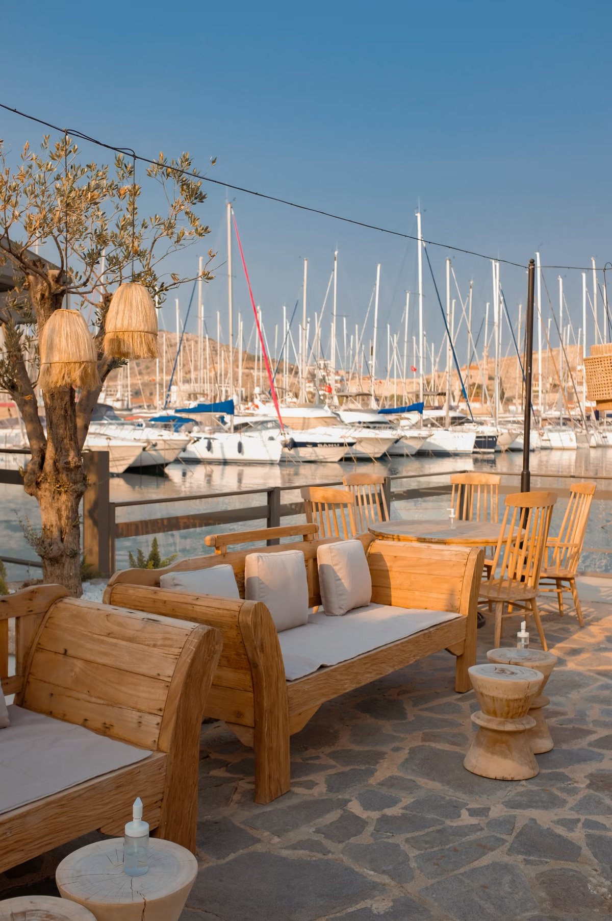 Restaurantterras met uitzicht op afgemeerde bootjes in de haven